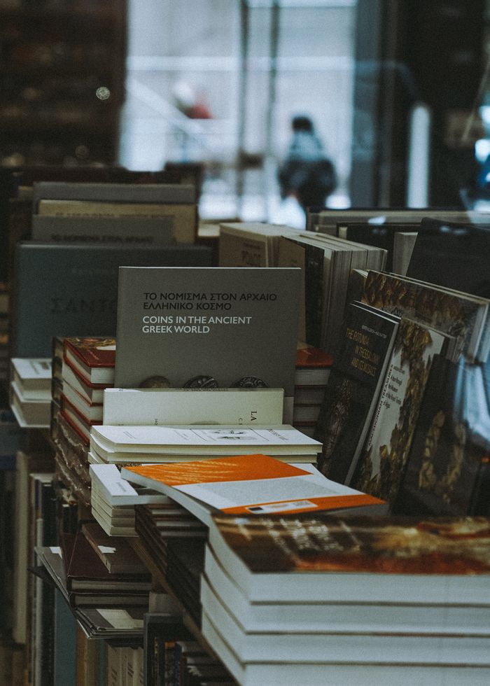 A collection of books stacked neatly on a bookstore shelf indoors.