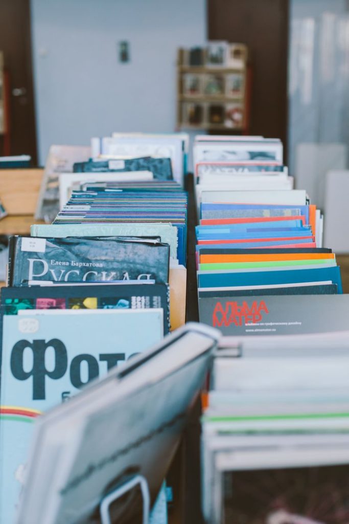 A neatly arranged collection of colorful magazines and books on library shelves.