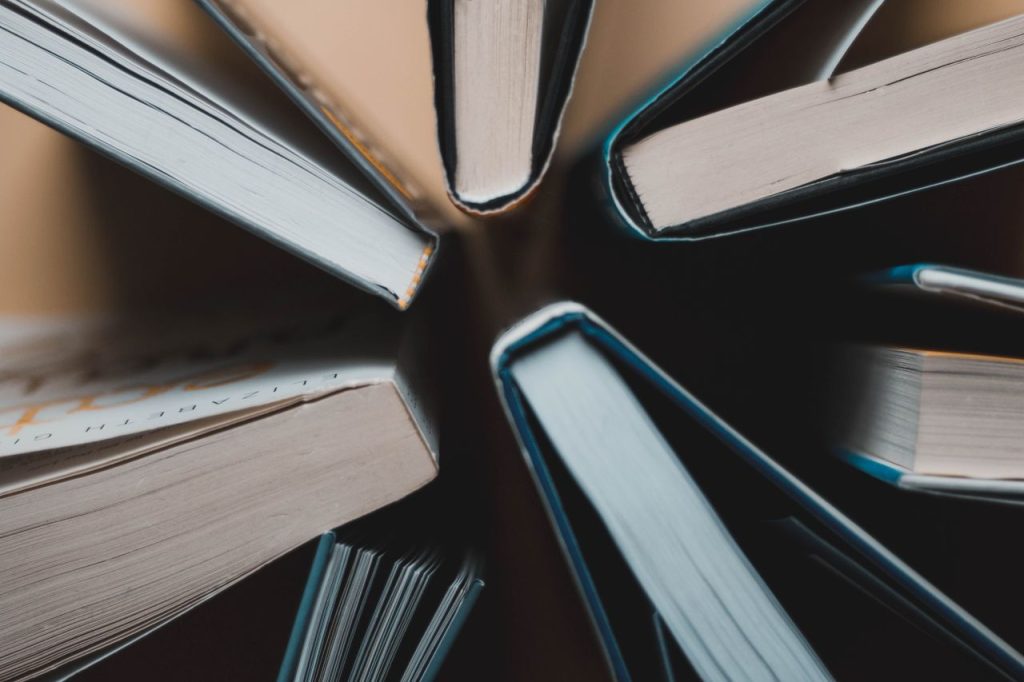 Top-down view of open books arranged in a circle showing spines and pages.